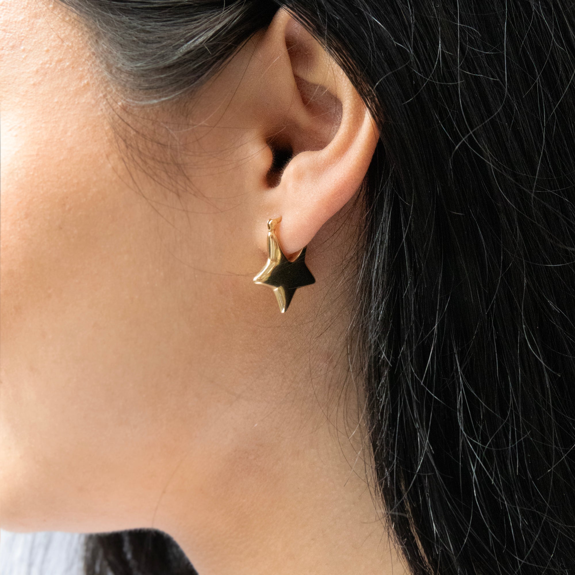 Gold star-shaped earring worn by a person with dark hair - Seol Gold
