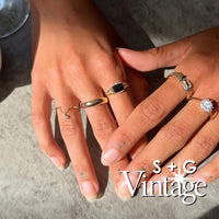 Two hands wearing gold and silver rings on a neutral background with 'S + G Vintage' branding - seolgold