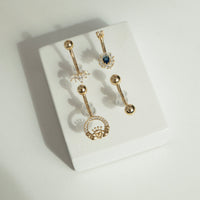 Set of gold belly buttons on a white surface - seolgold