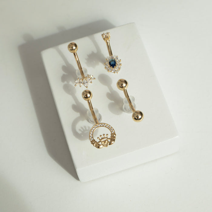 Set of gold belly buttons on a white surface - seolgold