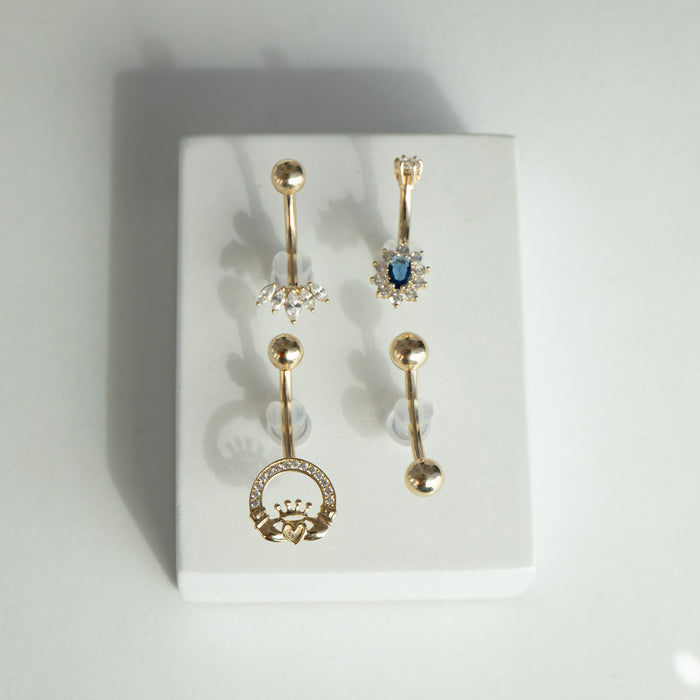 Set of gold belly button rings with gemstones on a white background - seolgold