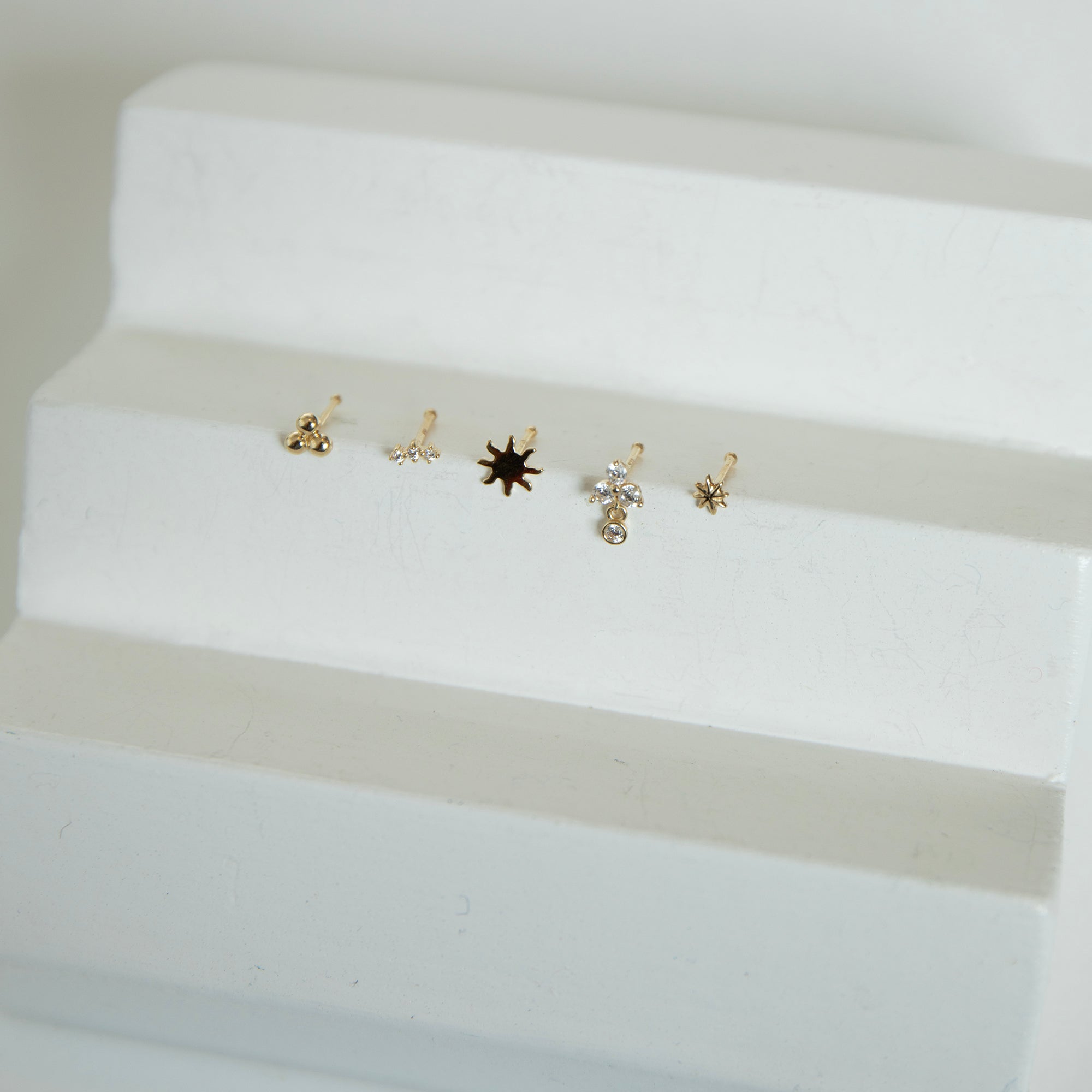 Set of small gold nose studs on a white surface - seolgold