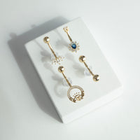 Set of 9ct gold belly buttons with decorative designs on a white surface - seolgold