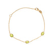 Gold bracelet with green gemstones on a white background - seolgold