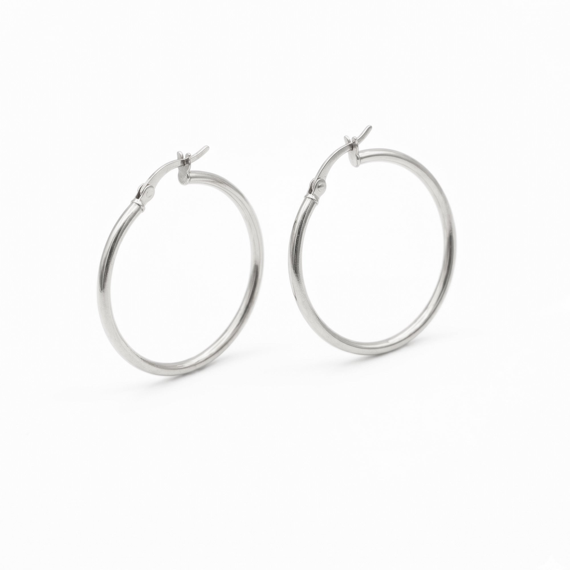 A pair of polished silver hoop earrings with a hinged clasp, shown on a clean white background - seolgold