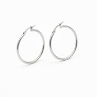 A pair of polished silver hoop earrings with a hinged clasp, shown on a clean white background - seolgold