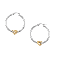 A pair of silver hoop earrings with a small gold heart-shaped knot at the bottom of each hoop, shown on a plain white background. Seol gold