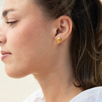 A close-up side profile of a woman wearing a small gold shell shaped stud earring - seolgold