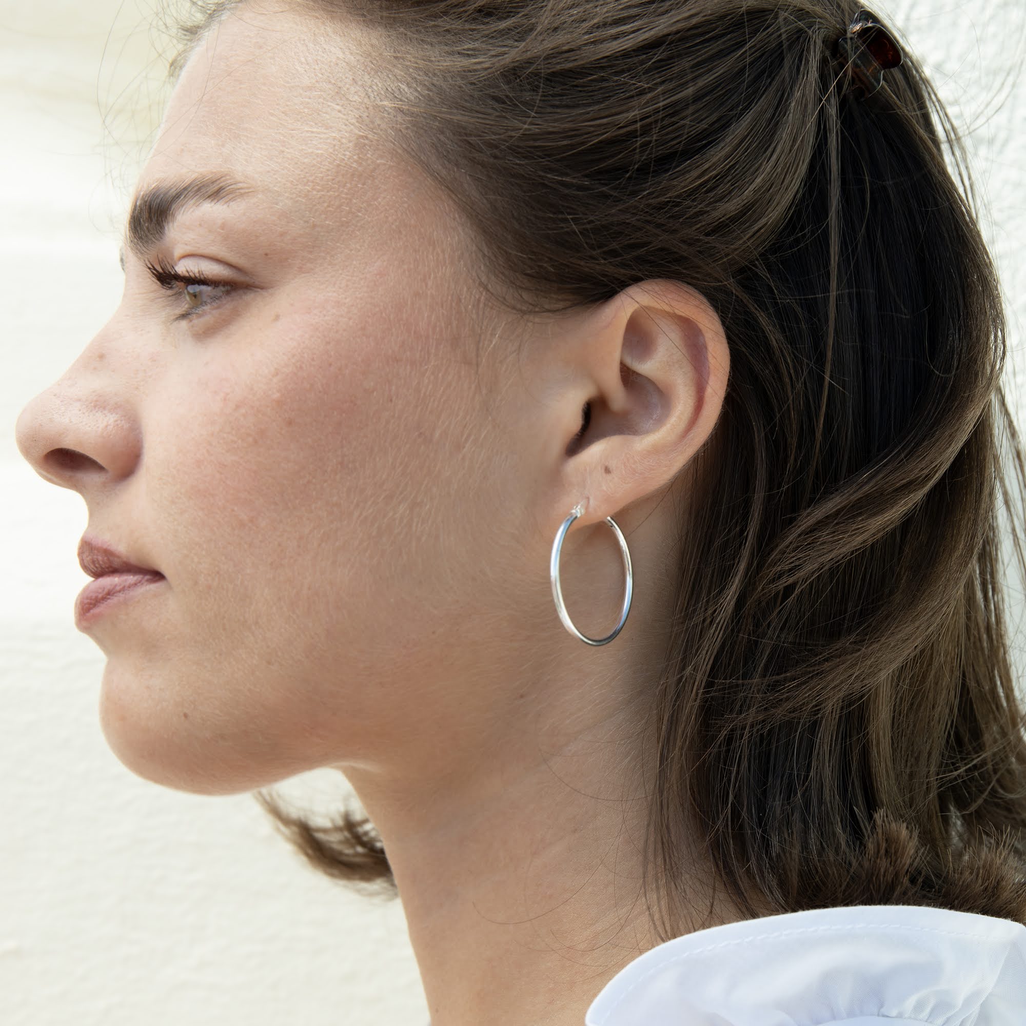 thin silver hoop earrings worn on a model - seolgold