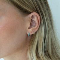 Gold hoop earrings with turquoise stones on a model against a white background - Seolgold