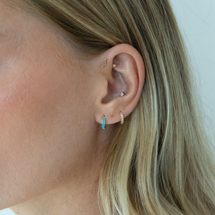 Gold hoop earrings with turquoise stones on a model against a white background - Seolgold