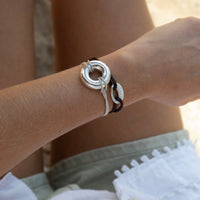 Close-up of a wrist wearing a silver bracelet with a textured design seolgold