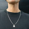 Person wearing a silver necklace with a letter 'S' pendant on a plain background - seolgold