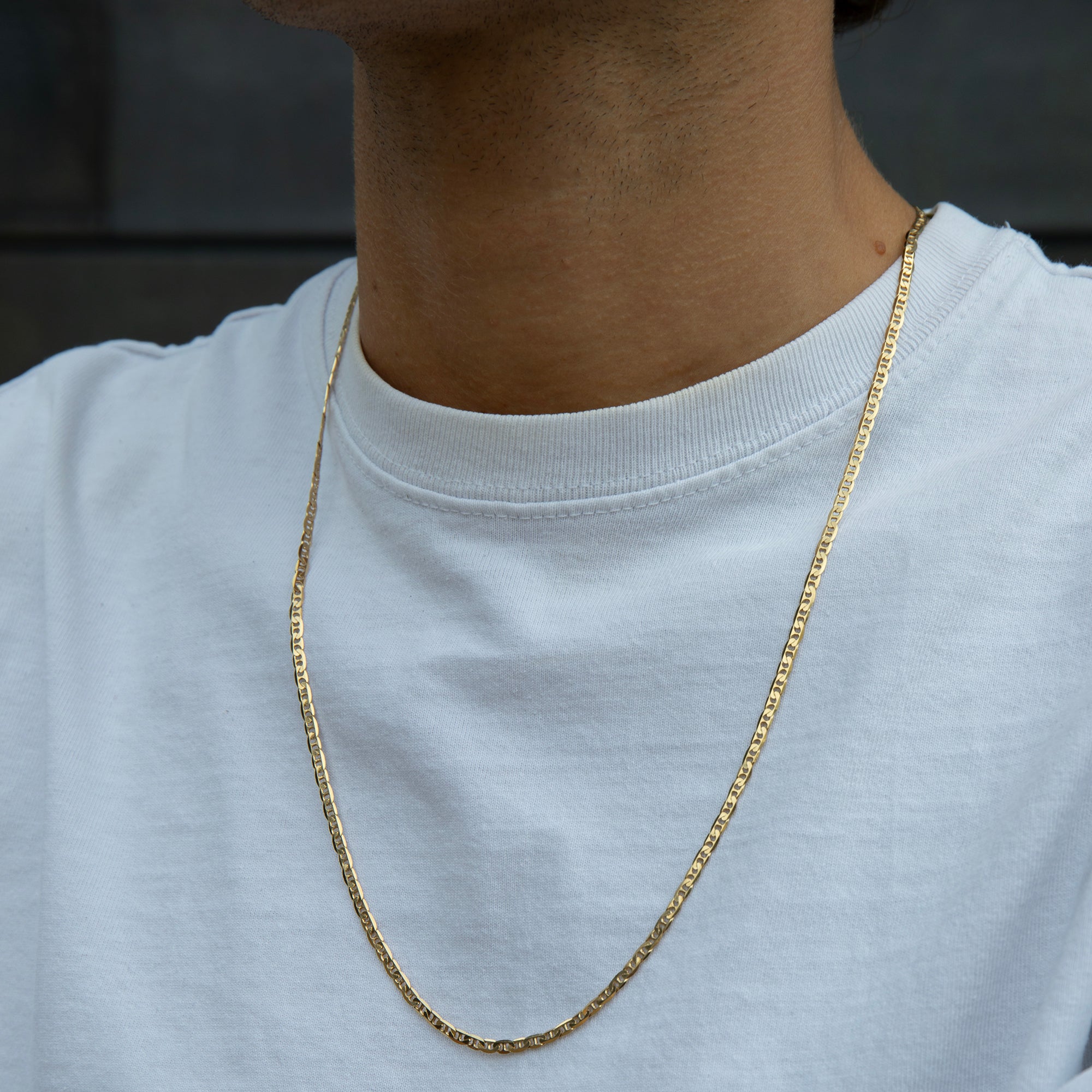 Gold chain necklace worn by a person on a plain background - seolgold