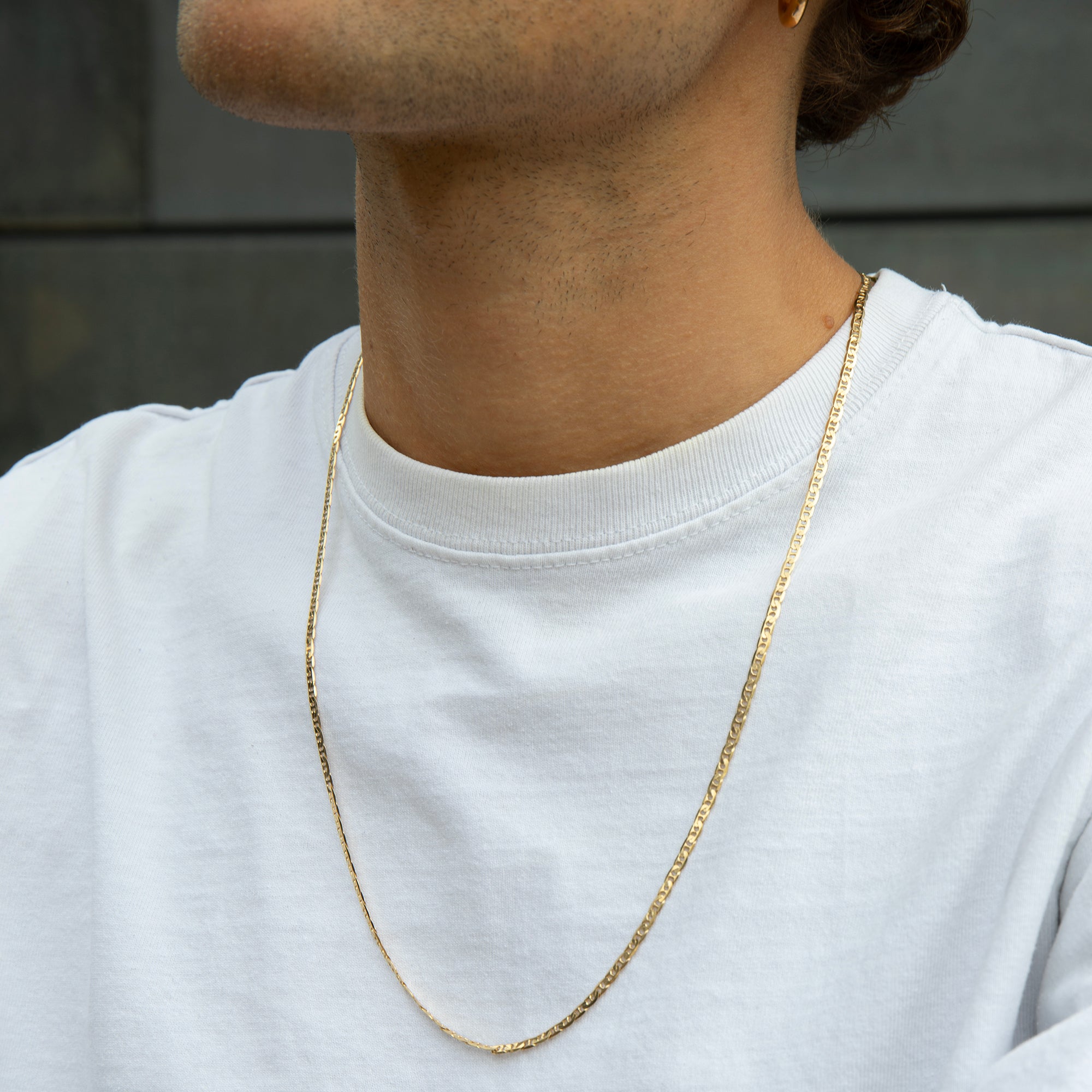 Person wearing a gold chain necklace against a neutral background - gold mens chain necklace - seolgold