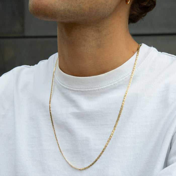 Person wearing a gold chain necklace against a neutral background - gold mens chain necklace - seolgold