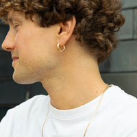 Close-up of a person wearing a gold hoop earring and necklace - seolgold