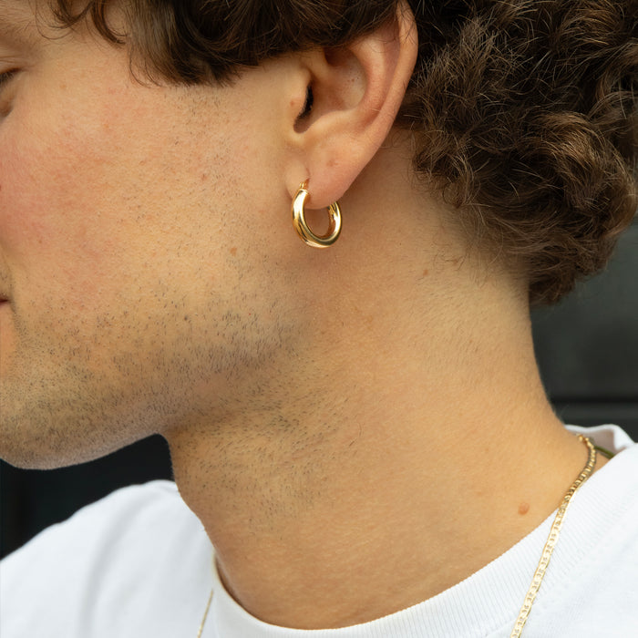 Close-up of a person wearing a gold hoop earring - seolgold