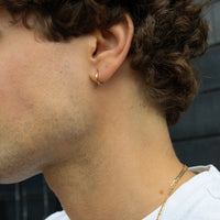 Close-up of a person wearing a gold hoop earring and necklace - seolgold