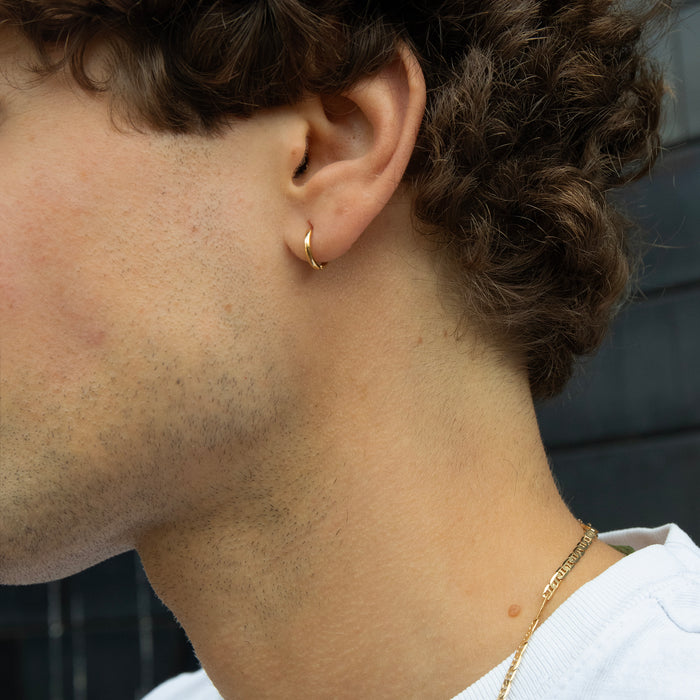 Close-up of a person wearing a gold hoop earring and necklace - seolgold