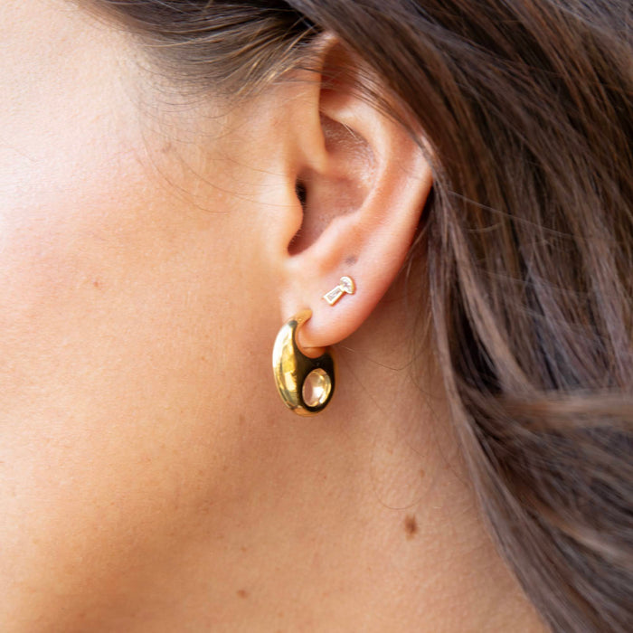 Close-up of a person wearing gold hoop earrings - seol gold