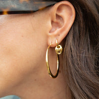 Gold hoop earring worn by a person with brown hair - large gold hoop - seolgold