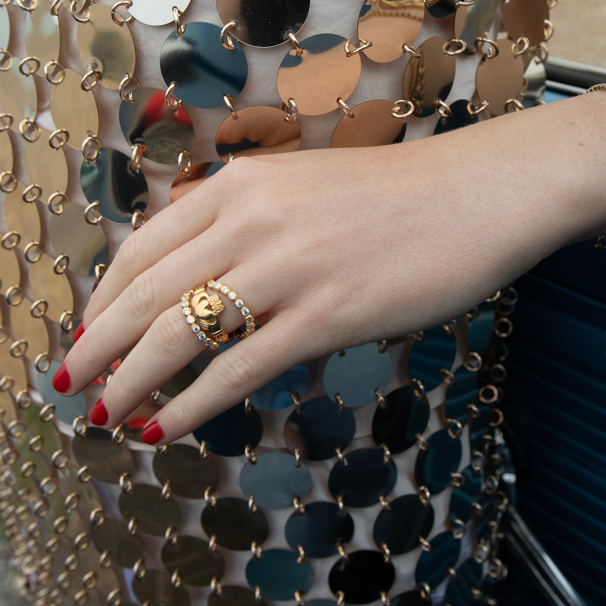 Hand wearing a gold ring with a colorful sequin background - seolgold