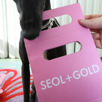 Pink product packaging with 'SEOL+GOLD' branding held by a person - seolgold