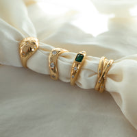 Set of gold rings with gemstones on a white fabric background - seolgold