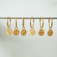 Set of gold hoop earrings with embedded coins on a gray background - seolgold