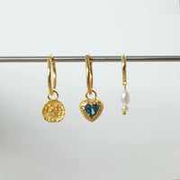 Three gold hoop earrings with unique charms on a white background - seolgold