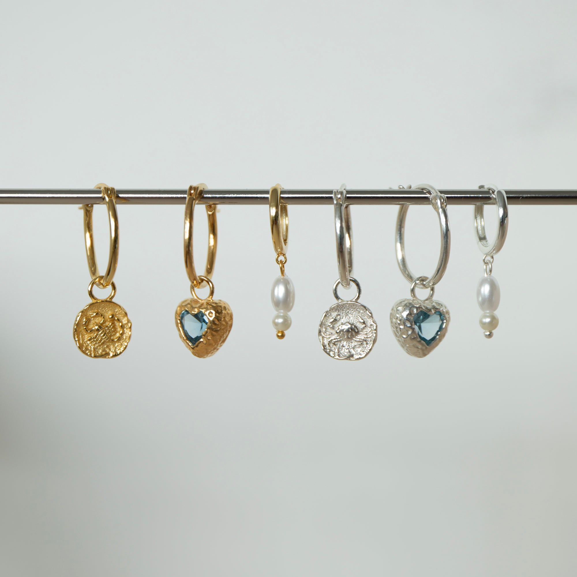 Set of gold and silver hoop earrings with various designs on a gray background - seolgold