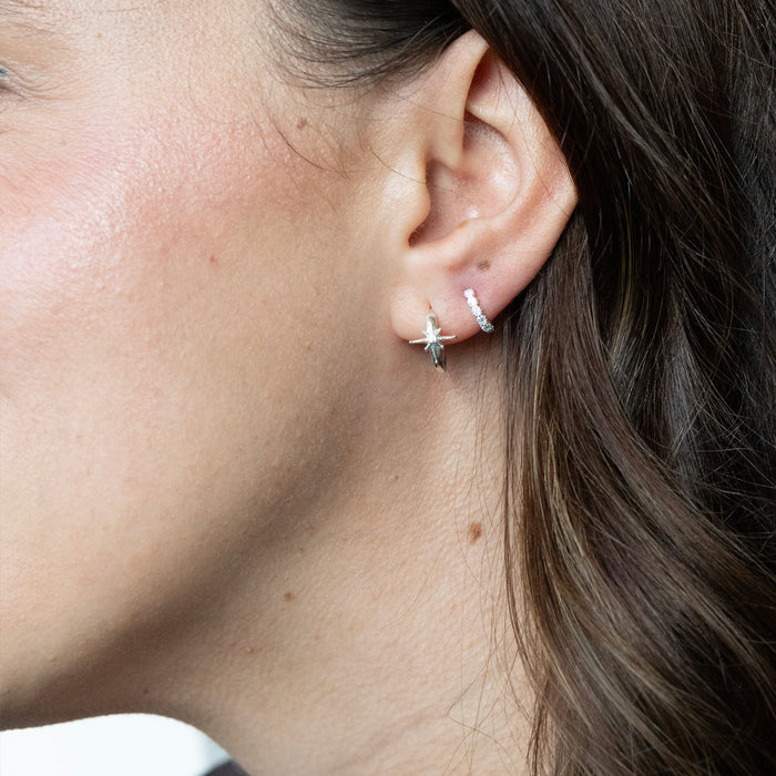 Close-up of a person wearing two earrings on their ear - seolgold