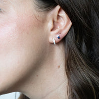 Close-up of an ear wearing a silver earring with small gemstones - seolgold