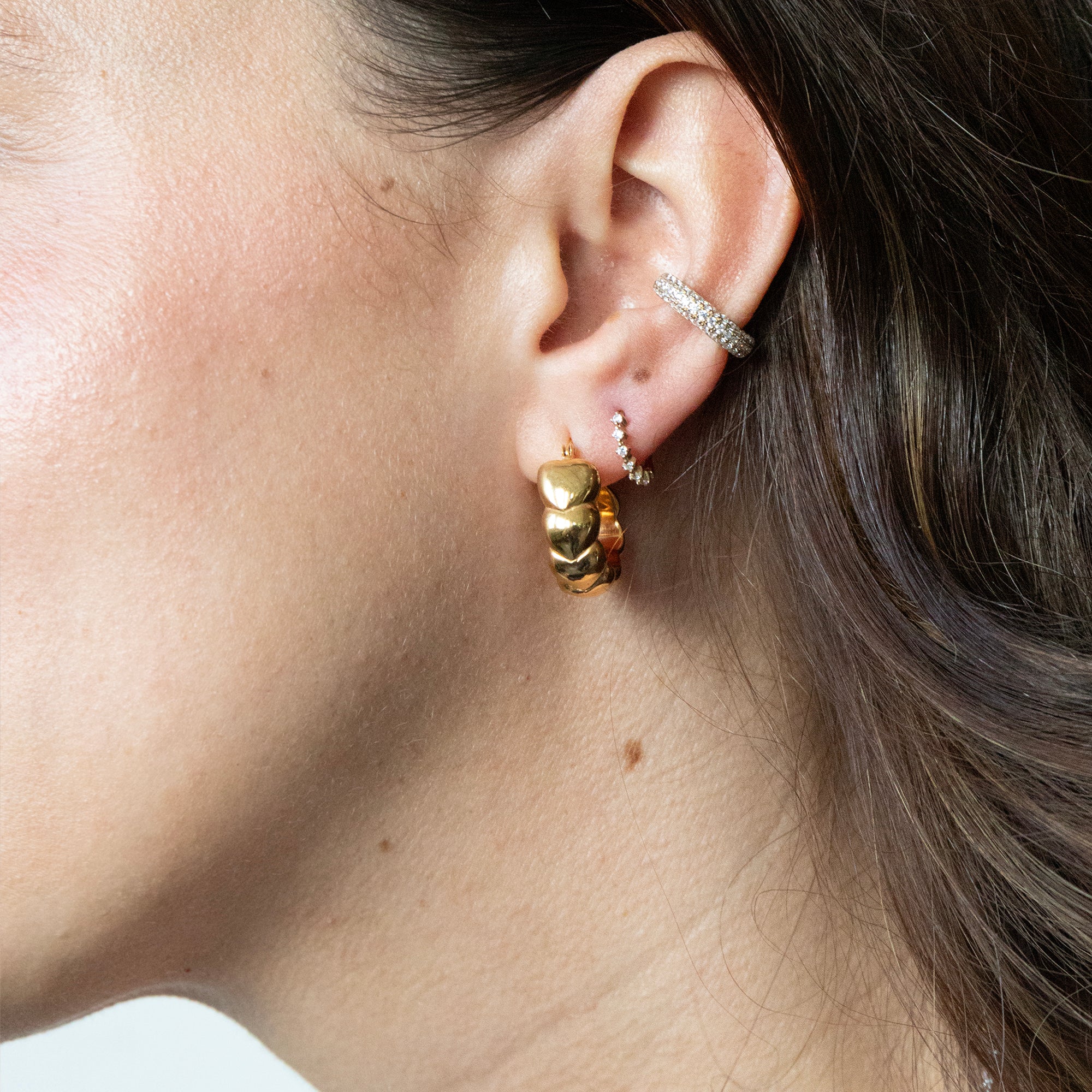 Close-up of an ear with gold hoop earrings - seolgold