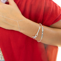 Silver anklet and bracelet on a person wearing a red garment - seolgold
