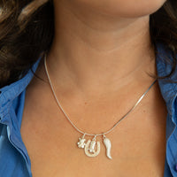 Necklace with horse-themed charms worn by a person in a blue shirt - seolgold