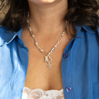 Necklace with 'S' charm worn by a person in a blue shirt - seolgold