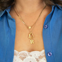 Gold necklace with 'LOVE' pendant worn by a person in a blue shirt with lace trim - seolgold
