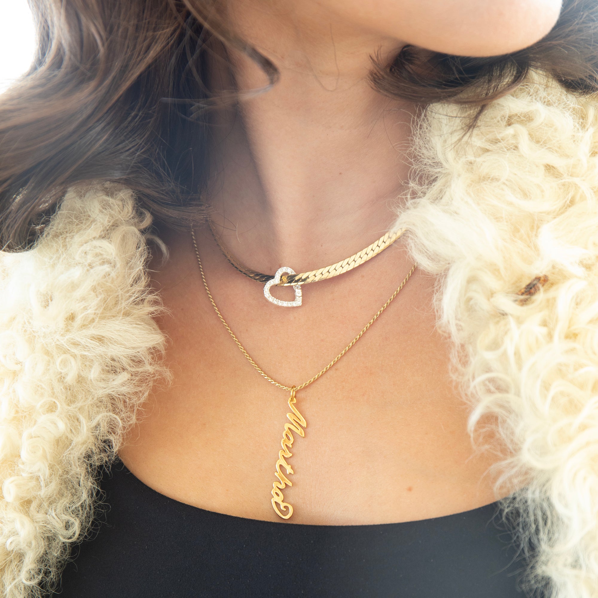 Person wearing a gold necklace with a heart pendant and another necklace with a name pendant, against a neutral background - 18ct Gold Vermeil Vertical Script Custom Name Plate - seolgold