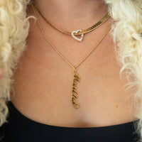 Gold necklace with a heart pendant and another necklace with a name pendant on a person with blonde hair - seolgold