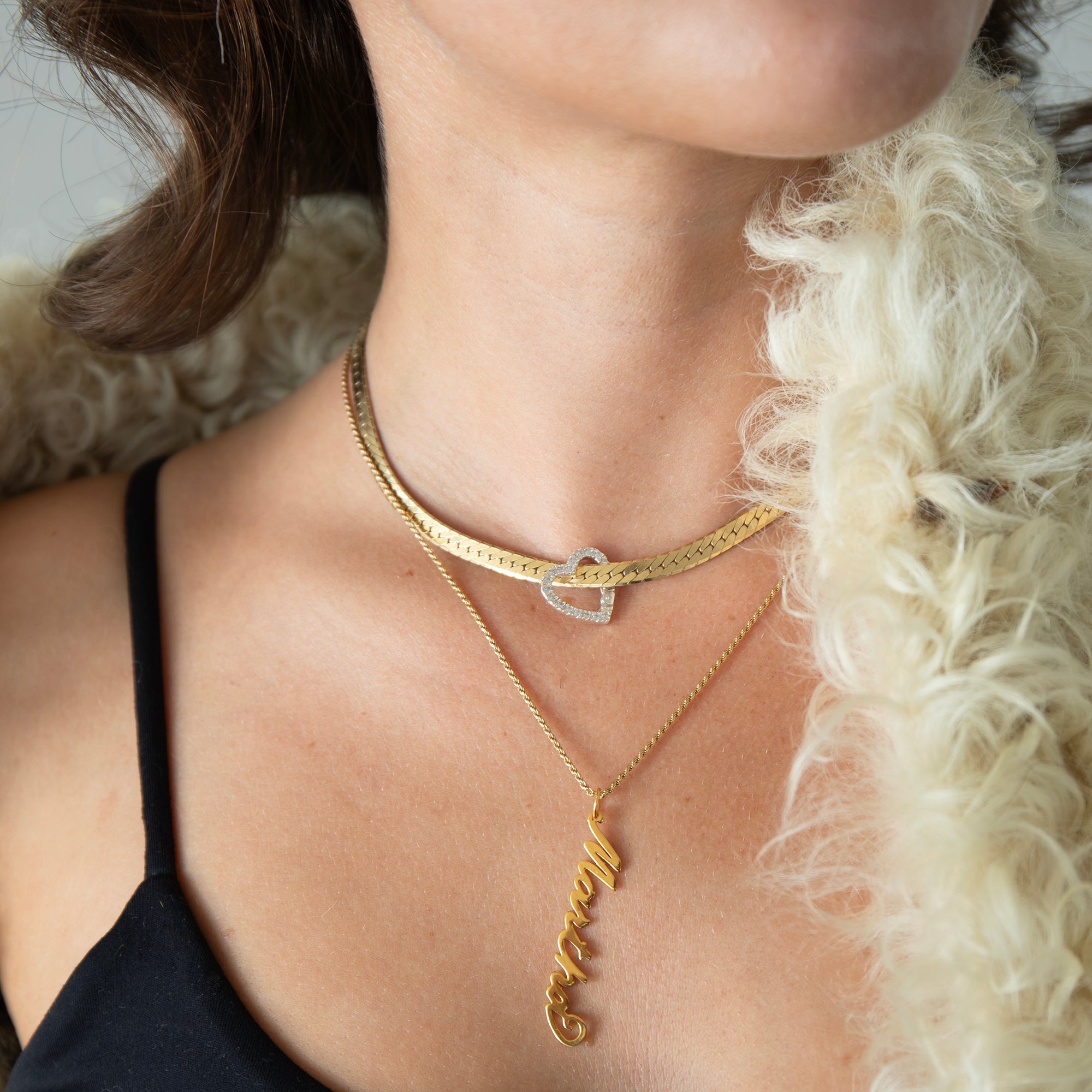Close-up of a person wearing two gold necklaces with a textured background - 18ct Gold Vermeil Vertical Script Custom Name Plate - seolgold