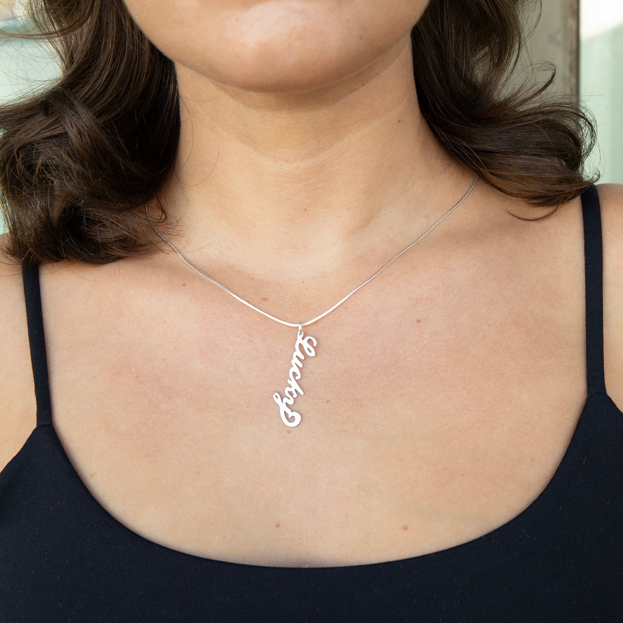 Person wearing a silver necklace with a 'Lucky' pendant - Sterling Silver Vertical Script Custom Name Plate - seolgold