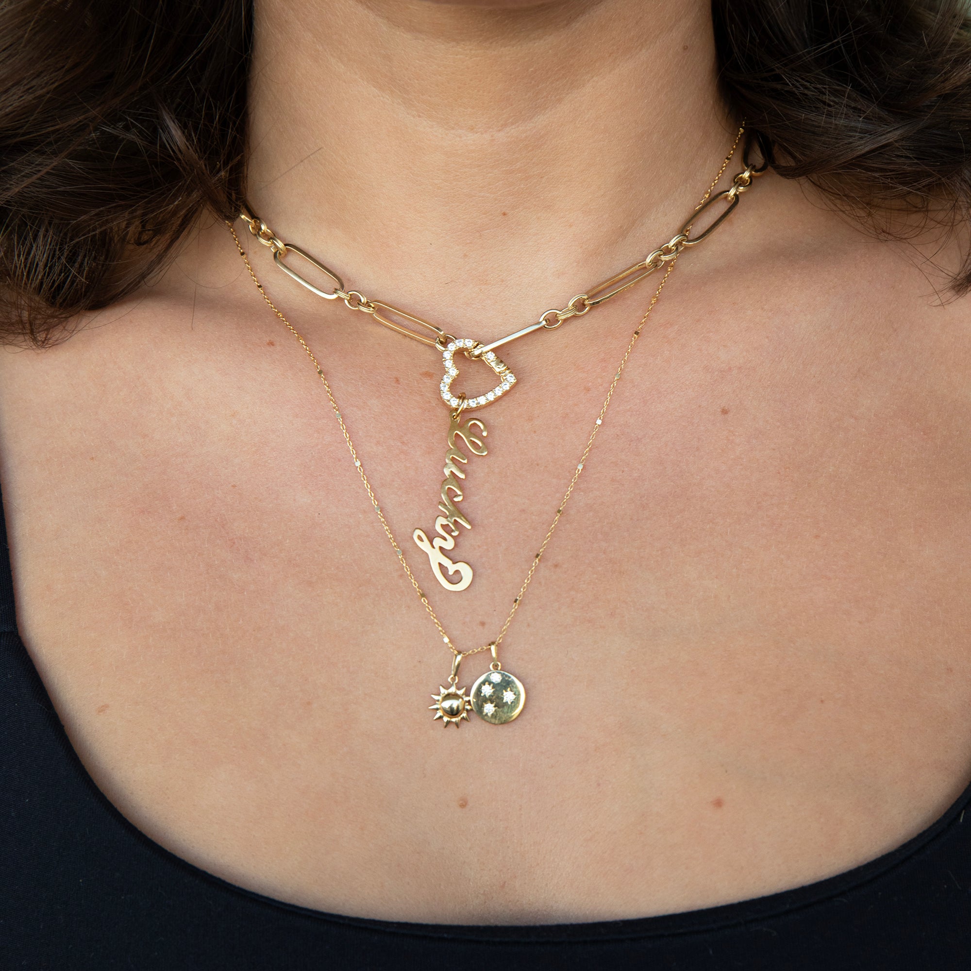 Close-up of a person wearing two gold necklaces with heart and name pendant - seolgold