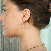 Close-up of a woman wearing a silver hoop earring - Sterling Silver Star Sign Charm Hoop Earrings - seolgold