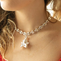 Silver chain necklace with a cherub angel shaped pendant worn by a person - seolgold