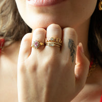 Close-up of a hand wearing gold rings with a tattoo on the ring finger - seolgold