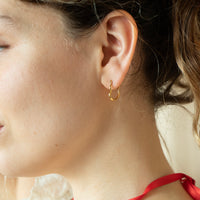 Close-up of a person wearing a gold hoop earring - seolgold