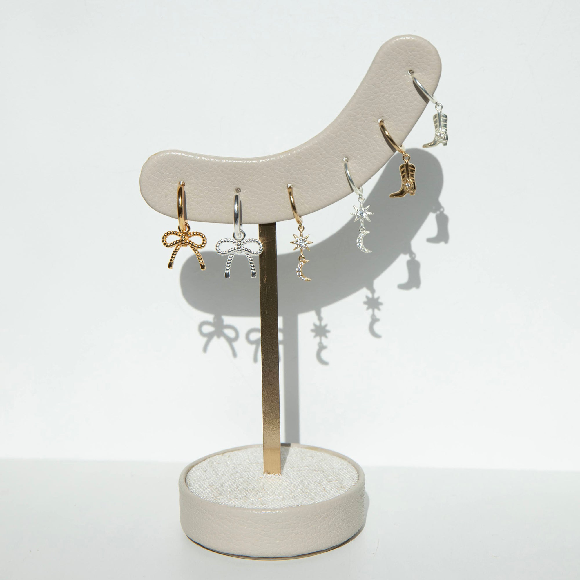 Earring stand with various earrings on a white background - seolgold
