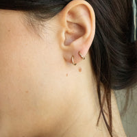 Close-up of an ear with gold hoop earrings - seolgold